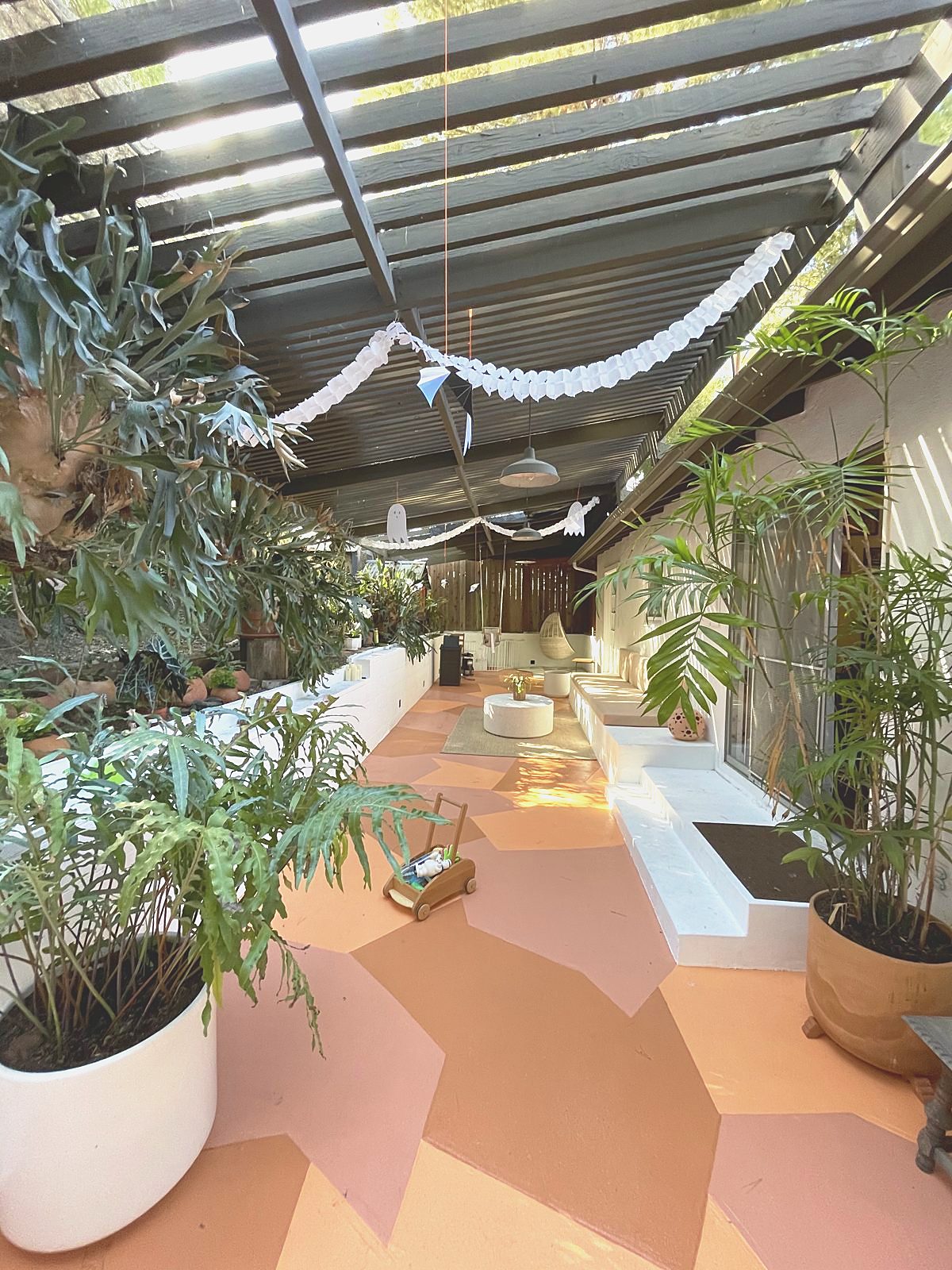 Plant-filled sunroom with painted geometric floor